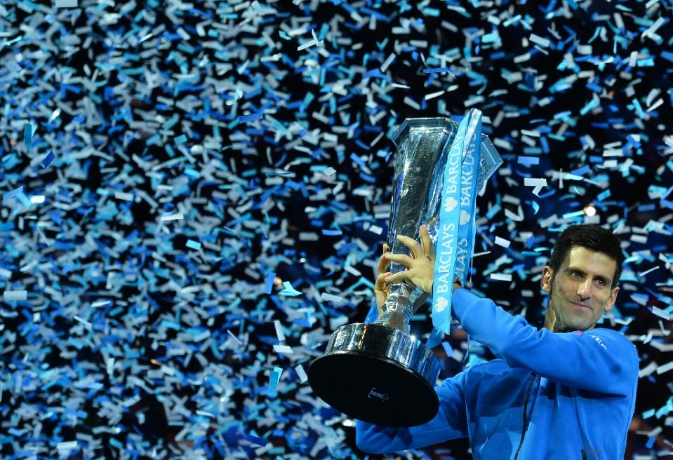 Serbia's Novak Djokovic holds up the ATP trophy after winning the men's singles final match against Roger Federer in London