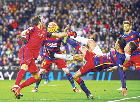 Barcelona's Chilean goalkeeper Claudio Bravo and Barcelona's midfielder Sergio Busquets vie with Real Madrid's Portuguese forward Cristiano Ronaldo during the Spanish league'Clasico football match Real Madrid CF vs FC Barcelona at the Santiago