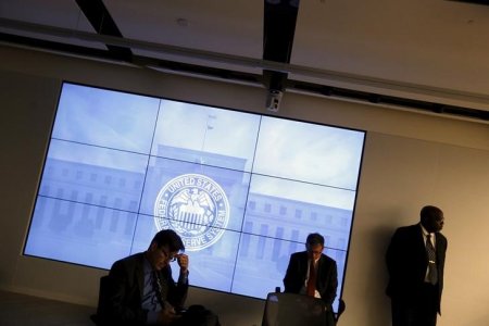 U. S. Federal Reserve staffers watch from the back of the room as Fed Chair Janet Yellen holds a news conference following the Federal Open Market Committee meeting in Washingt