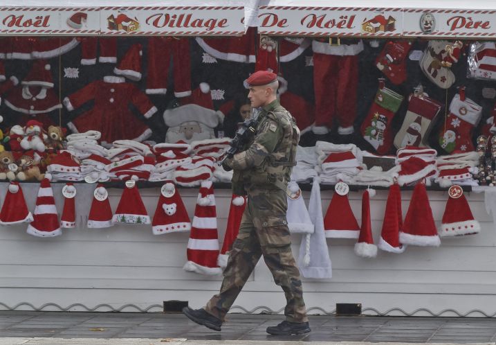 A soldier patrols at the Christmas market along the Champs Elysees avenue in Paris on Tuesday. French authorities on Tuesday questioned a top suspect linked to attackers who terrorized Paris while Belgium's capital remained locked down under threat of