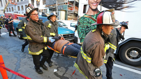 Firemen carry away a passenger injured on the bus