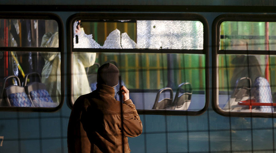 Forensic personnel investigate a bus with windows broken by bullets after an attack in Sarajevo