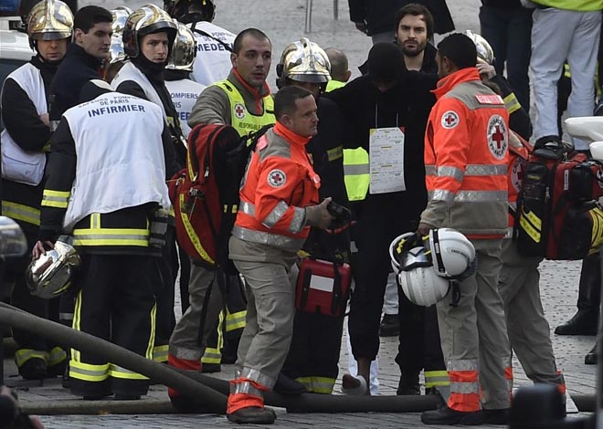 An injured policeman is evacuated as French Police special forces raid an apartment hunting those behind the attacks that claimed 129 lives in the French capital five days ago in the northern Paris suburb of Saint Denis city centre. — AFP