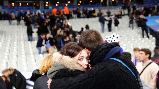 A supporter conforts a friend after invading the pitch of the Stade de France stadium at the end of the international friendly soccer match between France and Germany in Saint Denis outside Paris Friday Nov. 13 2015. Hundreds of people spilled onto