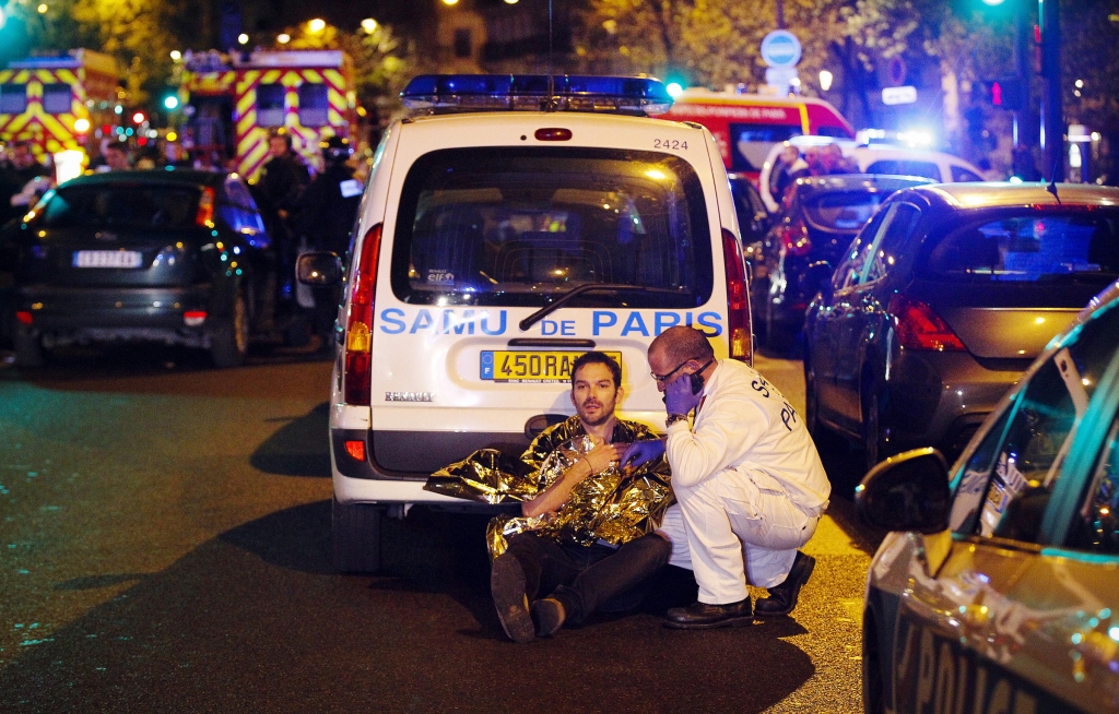 A medic tends to a man near the Boulevard des Filles-du Calvaire on Friday evening. According to French officials the attacks killed 128 people and left many more wounded