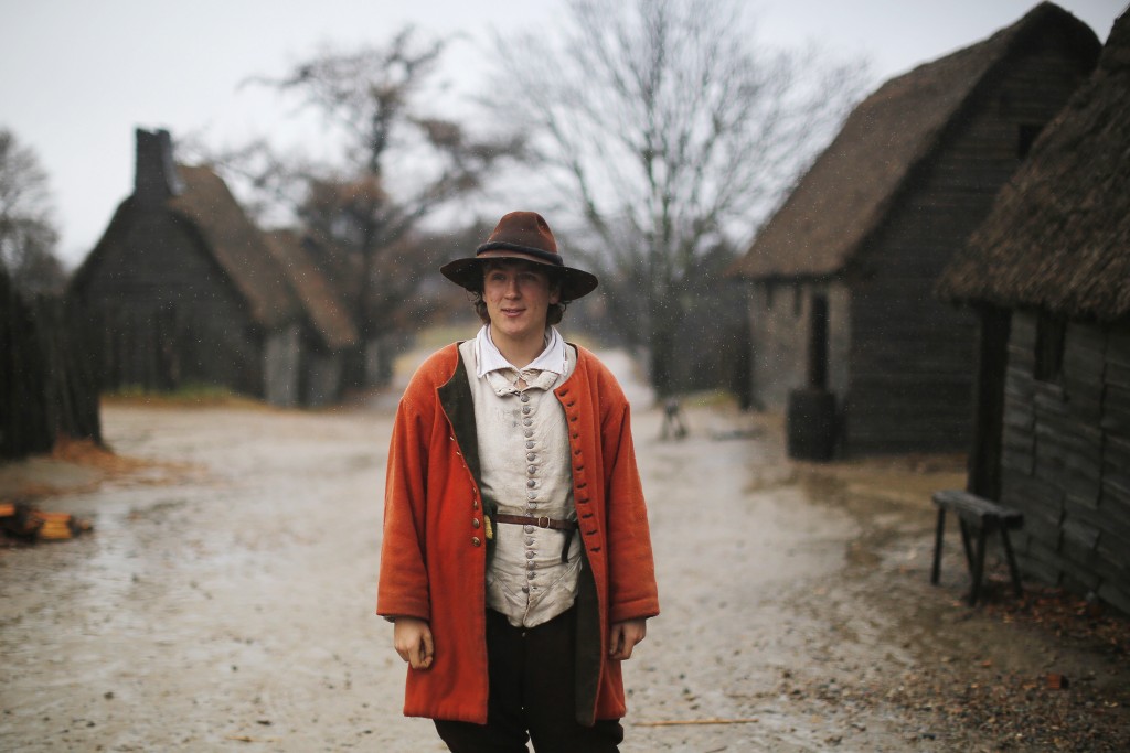 A man playing the role of John Billington stands in the rain in the street at Plimoth Plantation in Plymouth Massachusetts