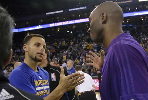 Golden State Warriors guard Stephen Curry left greets Los Angeles Lakers guard Kobe Bryant before an NBA basketball game in Oakland Calif. Tuesday Nov. 24 2015