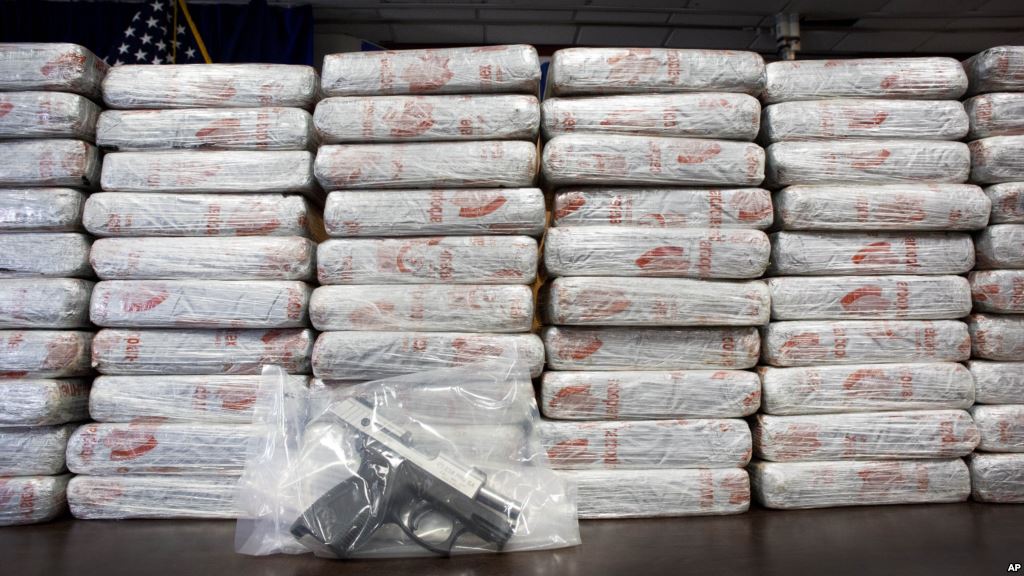 FILE- A firearm and 154 pounds of heroin worth at least $50 million are displayed by the Drug Enforcement Administration in New York