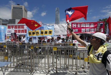 A pro-democracy protester carrying a Taiwan flag demonstrates in front of pro China supporters waving a Chinese national flag outside Legislative Council in Hong Kong China