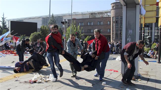 People carry an injured man after the deadly twin blasts in Ankara Turkey