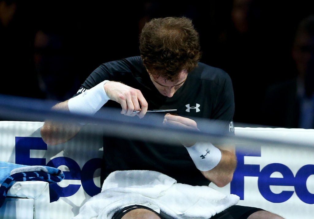 Andy Murray cuts his hair in-between games during his men's singles match against Rafael Nadal of Spain at the Barclays ATP World Tour Finals at the O2 Arena