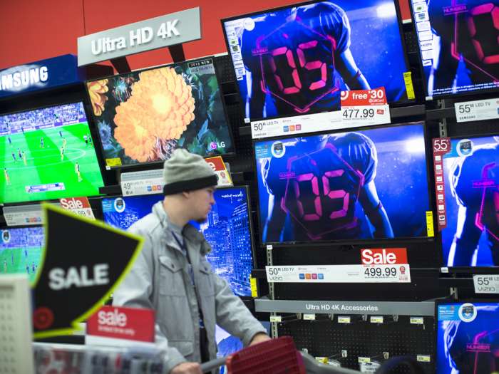 A holiday shopper browses the electronics section against a backdrop of televisions at a Target store Friday Nov. 27 2015 in Newport Ky. Associated Press