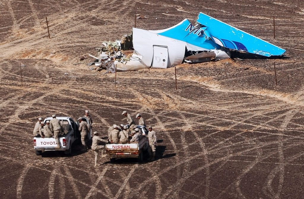 Egyptian Military on cars approach a plane's tail at the wreckage of a passenger jet bound for St. Petersburg in Russia that crashed in Hassana Egypt on Sunday Nov. 1 2015. The Russian cargo plane on Monday brought the first bodies of Russian victims