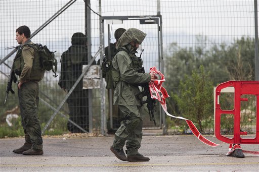 Israeli soldiers clear a road after a Palestinian woman was shoot dead after she drew a knife in check point near the West Bank Palestinian town of Qalqilya Monday Nov. 9 2015. Defense Ministry spokeswoman Arielle Heffez says the woman ignored warning