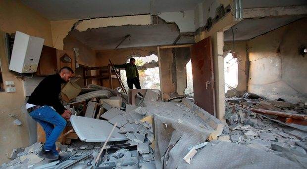 Palestinians inspect the rubble of a Palestinian house that was demolished by Israeli troops in the West Bank city of Nablus