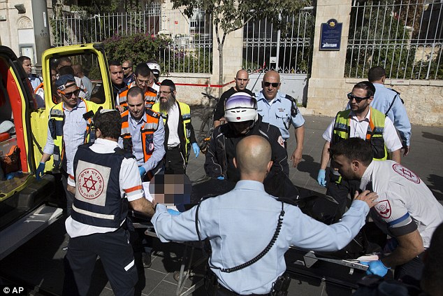 Carried Medics evacuate the body of a Palestinian women shot at the scene where police say she stabbed a man at the Mahane Yehuda market in downtown Jerusalem