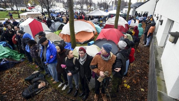 Protesters form a human chain to protect their encampment in front of a Minneapolis police precinct during a protest against the police shooting of Jamal Clark