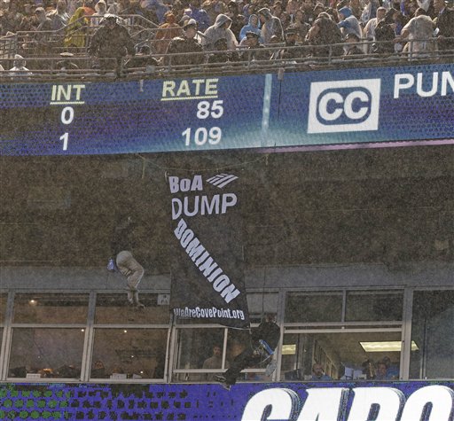 A police officer looks from above as two people hang a banner from the upper deck of Bank of America stadium in the second half of an NFL football game between the Carolina Panthers and the Indianapolis Colts in Charlotte N.C. Monday Nov. 2 2015. (AP