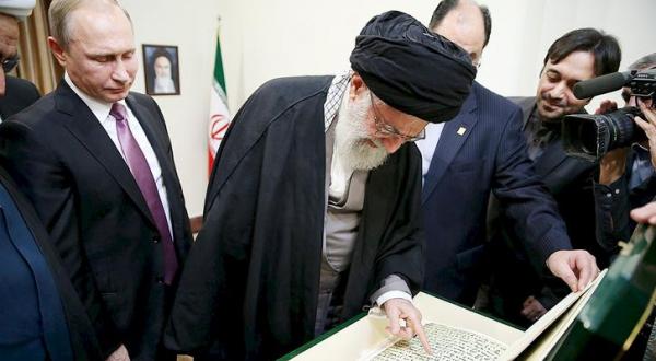 Khamenei looks at a copy of the Holy Qur’an gifted to him by Putin during their meeting in Tehran yesterday