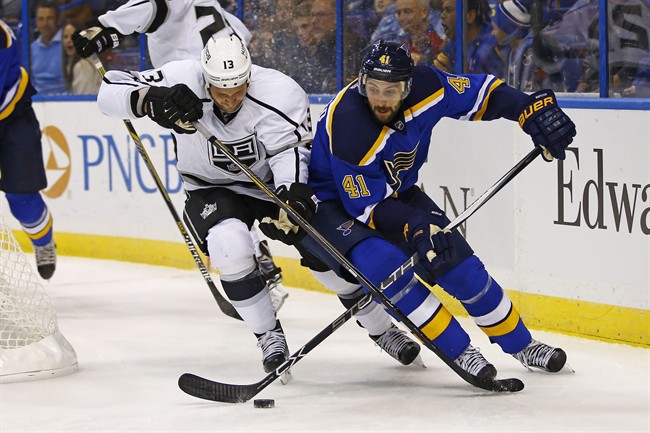 Los Angeles Kings’ Kyle Clifford left and St. Louis Blues’ Robert Bortuzzo battle for the puck during the first period of an NHL hockey game Tuesday Nov. 3 2015 in St. Louis