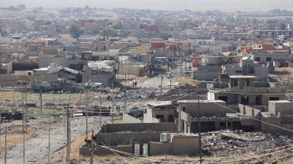 Kurdish peshmerga fighters seen in the center of this image enter Sinjar on Friday after taking the town from the self-proclaimed Islamic State group in a joint operation with coalition forces