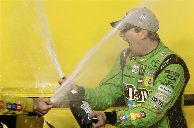 Kyle Busch celebrates after winning the NASCAR Sprint Cup Series auto race and the season title Sunday Nov. 22 2015 at Homestead Miami Speedway in Homestead Fla