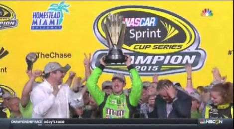 Kyle Busch raises his trophy after winning the NASCAR Sprint Cup Series auto race and the season title Sunday Nov. 22 2015 at Homestead Miami Speedway in Homestead Fla