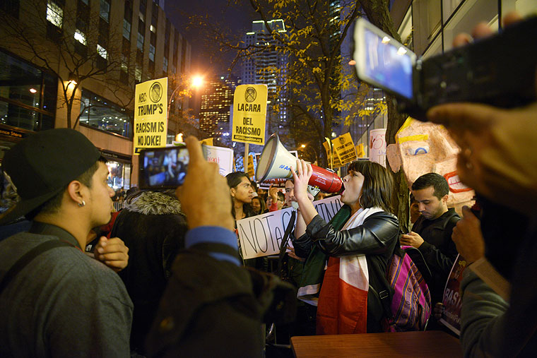 Karina Garcia of the ANSWER Coalition uses a megaphone to lead demonstrators in a chant during a protest against Republican presidential candidate Donald Trump's hosting'Saturday Night Live in New York Saturday Nov. 7 2015. Despite a 40-year