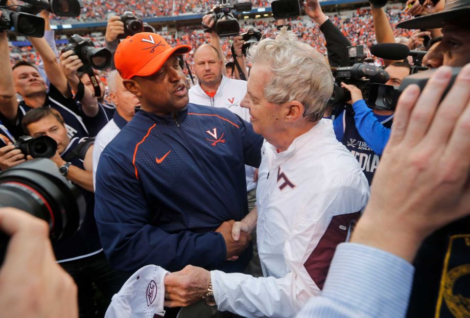 Virginia head coach Mike London left and Virginia Tech head coach Frank Beamer greet each other after an NCAA college football game in Charlottesville Va. Saturday Nov. 28 2015. Virginia Tech won the game 23-20