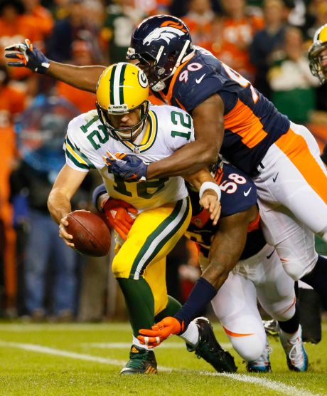 Green Bay Packers quarterback Aaron Rodgers is sacked by Denver Broncos defensive end Antonio Smith and outside linebacker Von Miller during the second half of an NFL football game in Denver