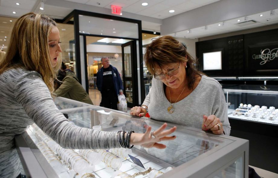 Alana Fusco left helps a customer at Gerald Peters a jewelry store at New York's Staten Island Mall. The store's lease requires it to open on Thanksgiving