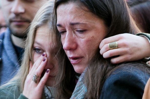 People react as they view tributes and flowers outside 'Le Bataclan&#x27