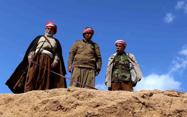 Members of the Yazidi community search for missing relatives in the remains of people killed by IS a day after Kurdish forces discovered a mass grave near the Iraqi village of Sinuni in the northwestern Sinjar area