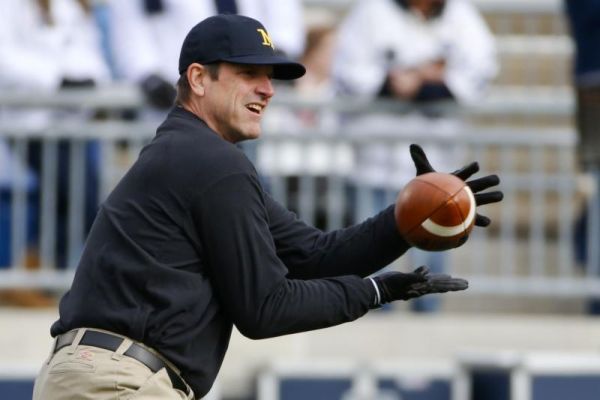 Michigan head coach Jim Harbaugh catches passes