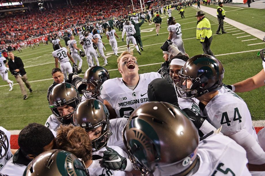 Michigan State players crowd around kicker Michael Geiger after Geiger's 41-yard field goal defeated Ohio State at Ohio Stadium on Saturday