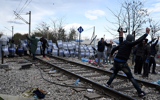 Migrants throw stones at Macedonian police at the Greek Macedonian border