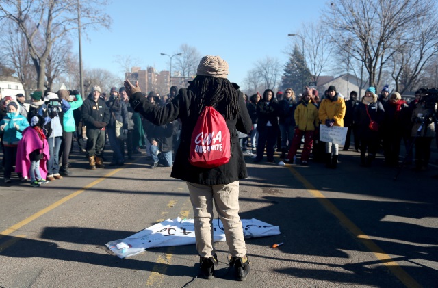 Alanna Galloway speaks to a crowd in front of a police precinct Saturday Nov. 21 2015 in Minneapolis. An encampment of protesters outside a Minneapolis police station vowed Saturday to maintain their vigil over the death of a black man who was shot