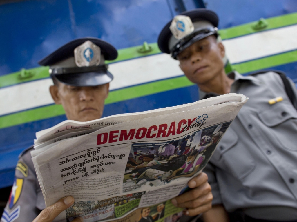 On Wednesday in Yangon Myanmar two police officers read about the elections that saw opposition leader Aung San Suu Kyi's party win a majority of seats in parliament