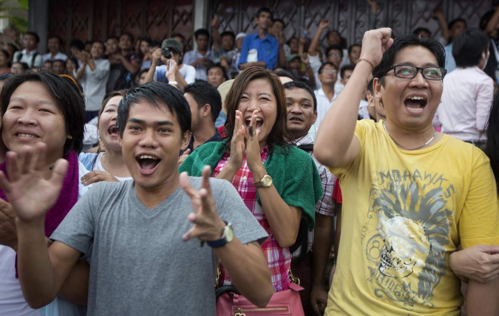 Supporters of Myanmar's National League for Democracy party cheer as they watch early voting results posted on a giant screen outside the NLD headquarters in Yangon Myanmar Sunday Nov. 8 2015