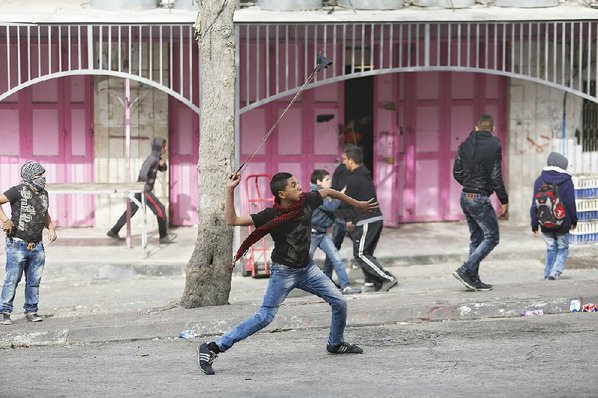 NASSER SHIYOUKHI						Credit AP				A Palestinian youth fires stones from his slingshot at Israeli troops Wednesday in the West Bank city of Hebron