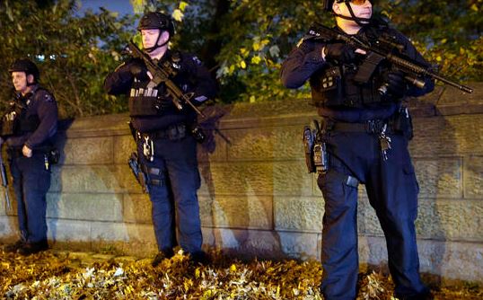 Heavily armed New York City police officers stand guard across the street from the French consulate on New York's Fifth Ave. Friday Nov. 13 2015. MARY ALTAFFER  AP