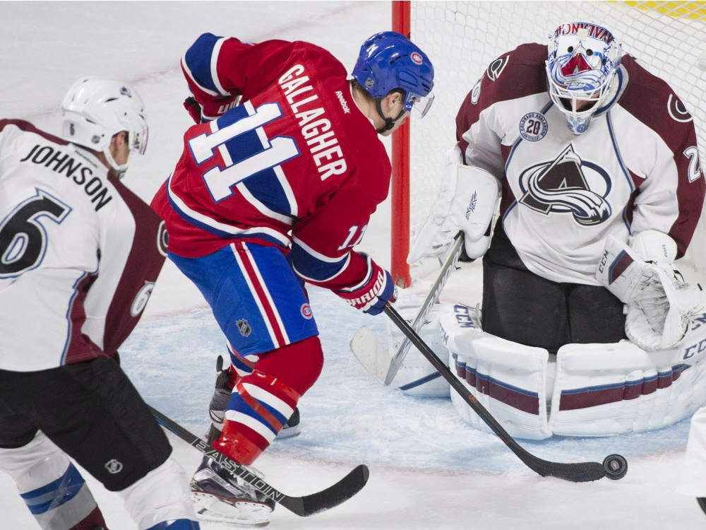 Montreal Canadiens&#039 Brendan Gallagher moves in on Colorado Avalanche's goaltender Reto Berra as the Avalanche's Erik Johnson defends during second period NHL hockey action in Montreal Saturday