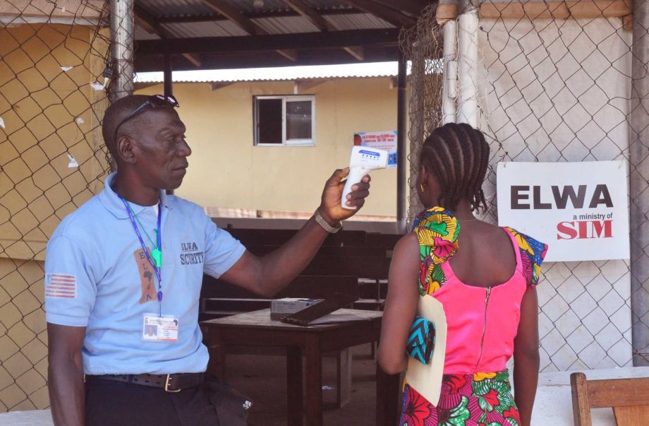 A unidentified family member right of a 10-year old boy that contracted Ebola has her temperature measured by a health worker before entering the Ebola clinic were the child is being treated on the outskirts of Monrovia Liberia Friday Nov. 20 2015