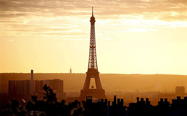 The Eiffel Tower in Paris France reaches into a golden sunset on Sunday