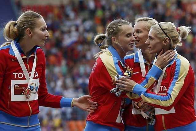 Gold medallists team Russia kiss and celebrate at the women's 4x400 metres relay victory ceremony during the IAAF World Athletics Championships at the Luzhniki stadium in Moscow