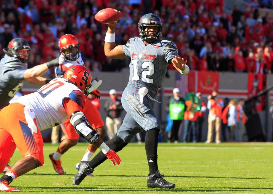 North Carolina State quarterback Jacoby Brissett looks to pass while under pressure from Syracuse's John Raymon during the first half of an NCAA college football game Saturday. Nov. 21,2015 at Carter Finley Stadium in Raleigh N.C. (Ethan Hyma