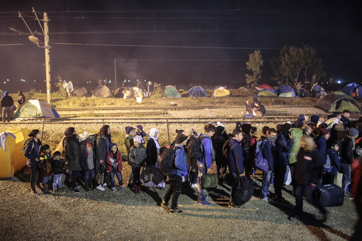 Migrants from Syria waits in line to cross the border near the northern Greek village of Idomeni