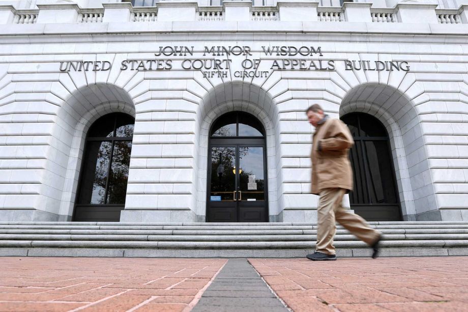 A man walks in front of the 5th U.S. Circuit Court of Appeals in New Orleans