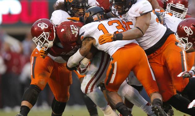 Oklahoma State defenders tackle Oklahoma's Samaje Perine during the Bedlam college football game between the University of Oklahoma Sooners and the Oklahoma State Cowboys at Gaylord Family Oklahoma Memorial Stadium in Nor