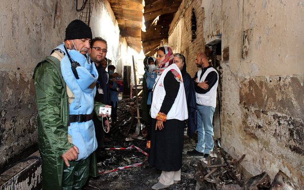 November 10,2015 an Afghan talks to staff members in a charred corridor of the damaged Medecins Sans Frontieres hospital in northern Kunduz. On